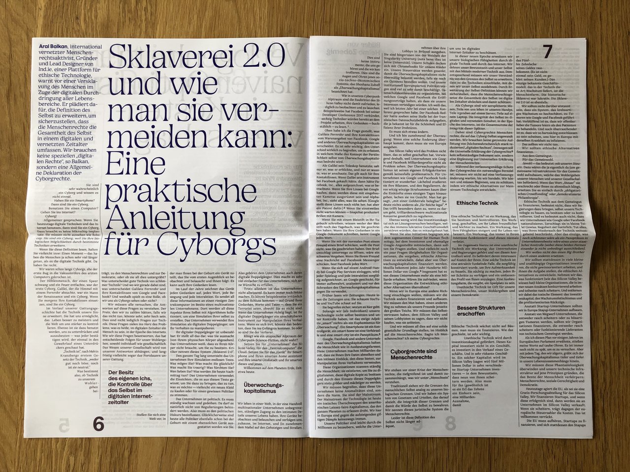 Magazine on wooden table, open, showing two-page article spread.
